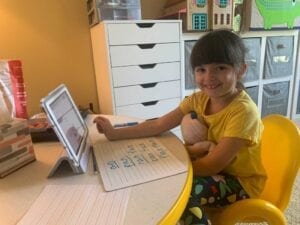 Avalon Cycyk attends school from her desk at home.