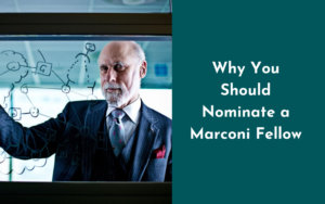 A man in a three piece suit writes on a board and looks at the camera; next to him are the words "Why You Should Nominate a Marconi Fellow"