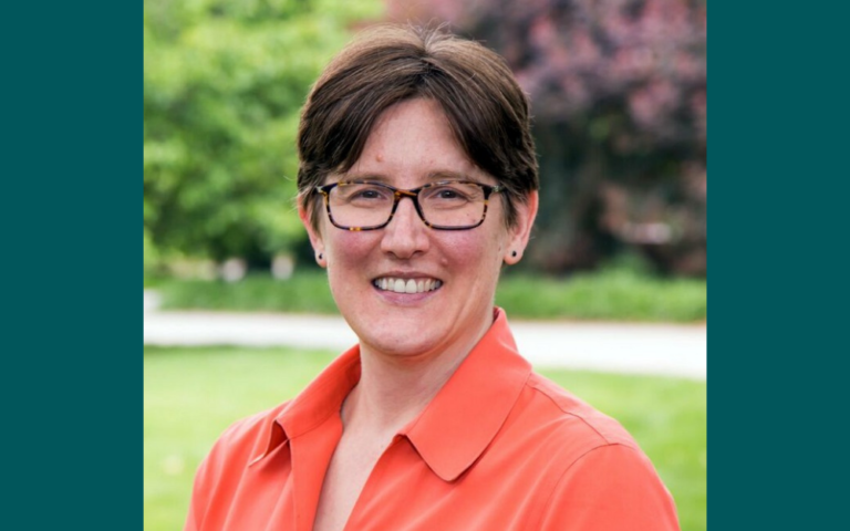 A photo of a woman with short hair and glasses