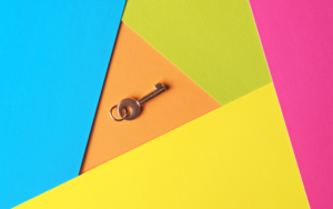 A small key against a colorful background of geometric shapes