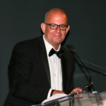 Man wearing glasses and a tuxedo.